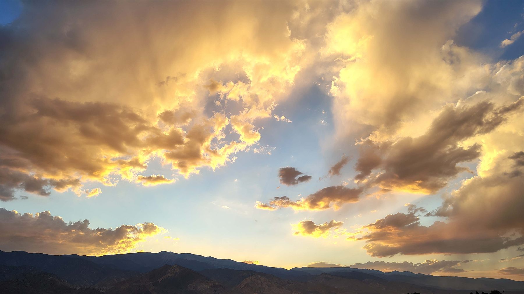 Sunlight breaking through clouds over mountains